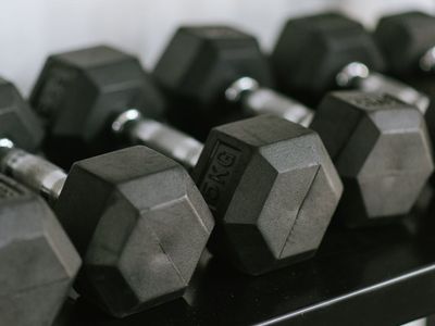 Set of black dumbbells on a metal rack